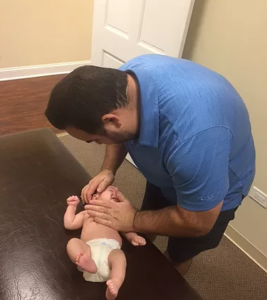 performing massage on baby